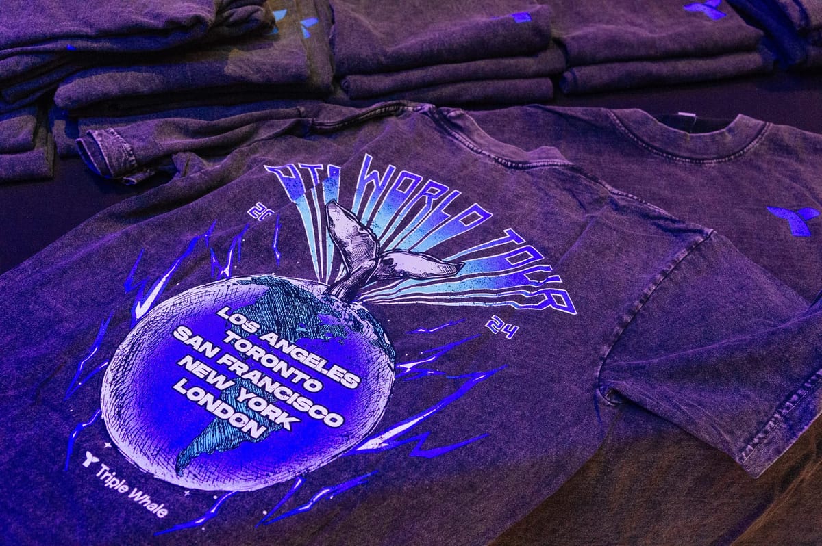 Stacked tour shirts printed with a whale tail, a globe and Los Angeles, Toronto, San Francisco, New York, London