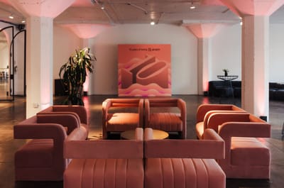 Peach velvet lounge seating in front of a 10 years of being gorgias backdrop with a large 3D 10