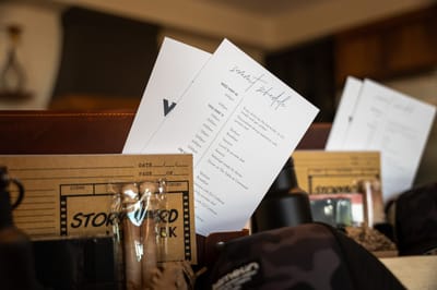 Summit schedule cards and Storyboard notebooks tucked into welcome gift boxes beside a camo cap