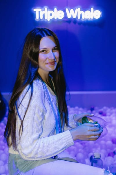 A guest in front of the Triple Whale neon at the edge of the pit