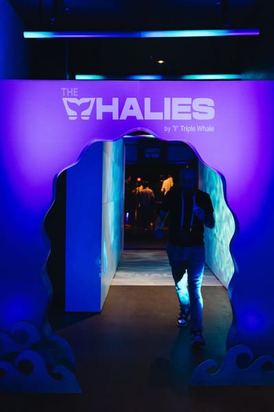 A guest walking through the wave-cut Whalies arch into a lit corridor