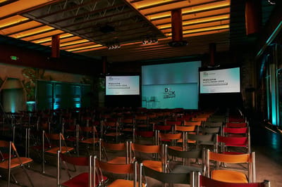 Main stage with a DTCx Retain backdrop between two screens reading Welcome to DTCx Retain 2024, above rows of chairs