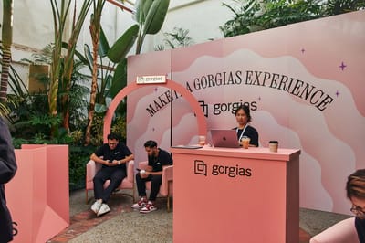 The coral arch and check-in desk in front of the Make It A Gorgias Experience wall