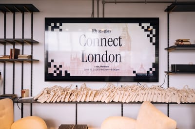Screen reading Gorgias Connect London, Labs, Holborn, June 18, 2026, above a shelf of branded tote bags