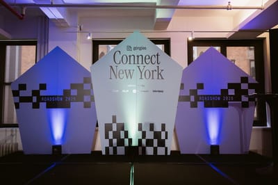 Gorgias Connect New York stage with three pointed checkered panels reading Roadshow 2026, lit in blue and green