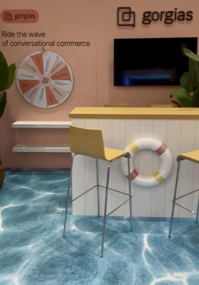 The Gorgias Beach Club booth with prize wheel, surf shack bar and printed water floor