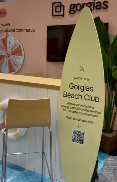 A surfboard signboard welcoming guests to the Gorgias Beach Club with a QR code