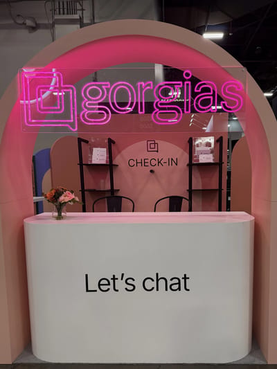 The Gorgias check-in under a pink arch carrying a magenta neon wordmark
