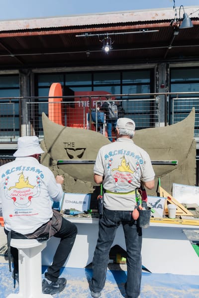 Two Archisand sculptors carving the tail on site before the doors opened
