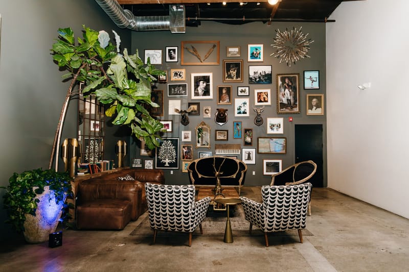 Lounge corner with a leather sofa, patterned armchairs and a wall of framed pictures