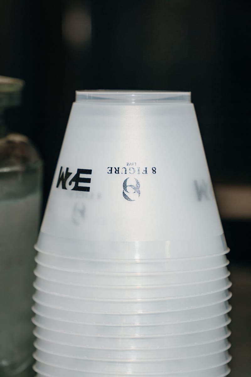 Stack of frosted cups printed with the 8 Figure Live and E2M logos