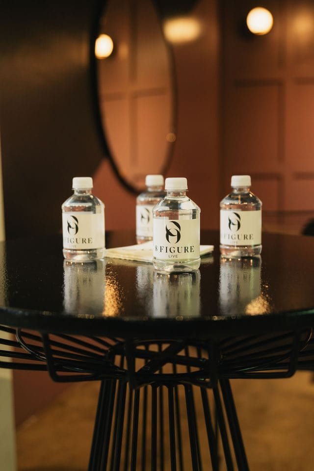 Branded water bottles on a small black table