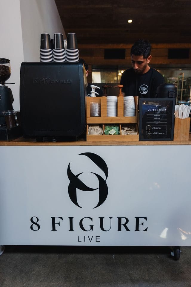 Coffee bar with the 8 Figure Live logo on its front