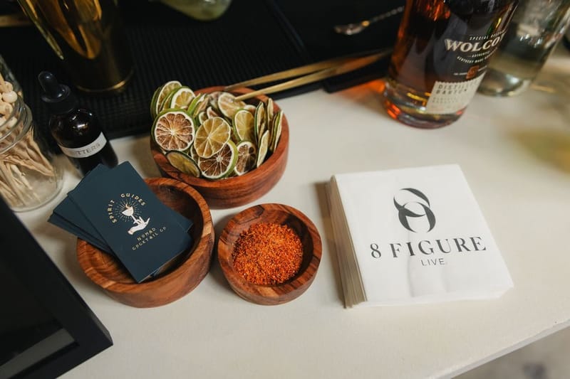Bar setup with dried citrus garnishes and 8 Figure Live napkins