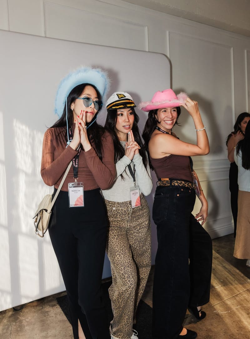 Three guests in cowboy hats and a captain's hat posing with props