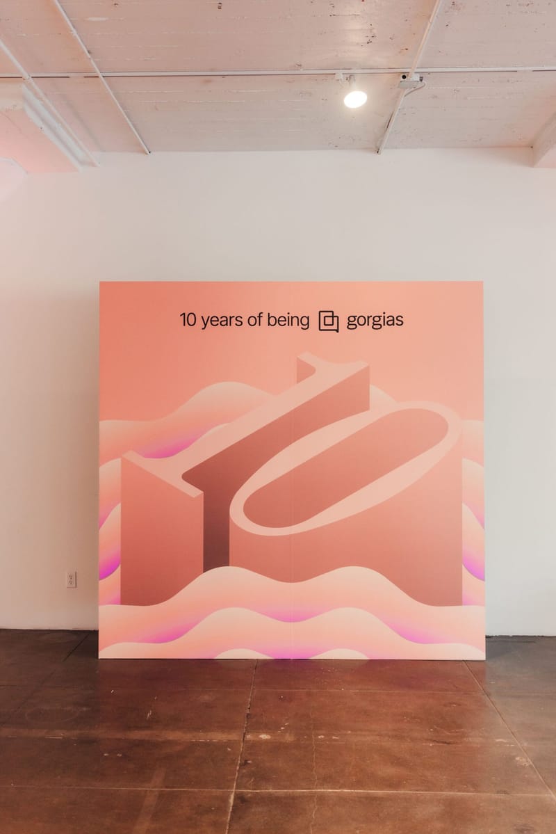 Backdrop printed with 10 years of being gorgias and a large 10 over pink waves