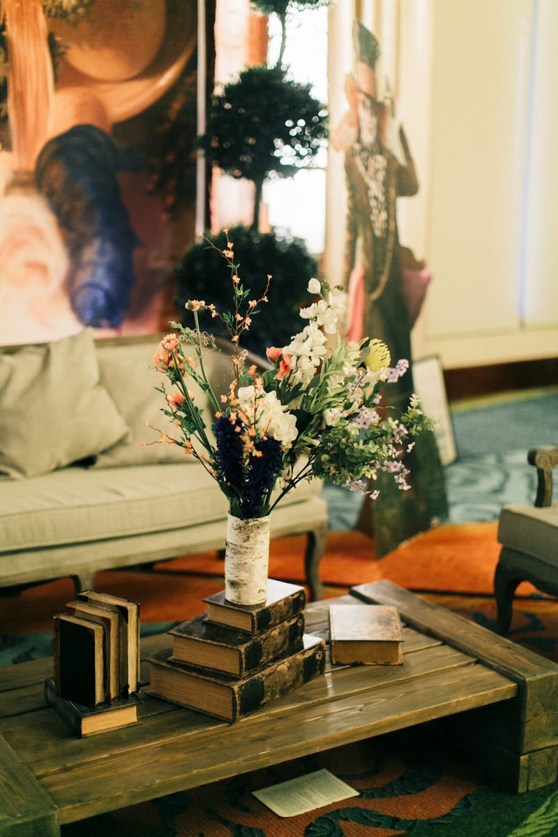 Wildflower bouquet on a stack of old books on a wooden coffee table beside a sofa