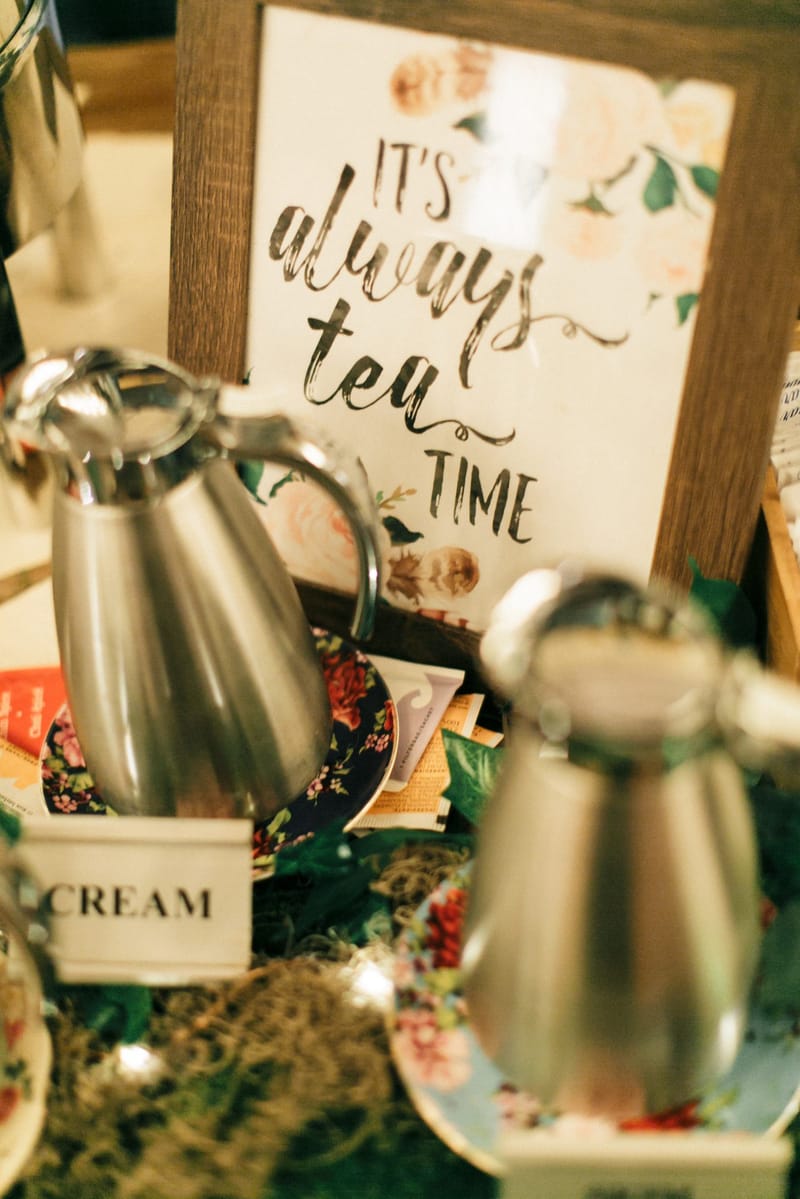 Silver carafes and a CREAM label in front of a framed sign reading It's always tea time