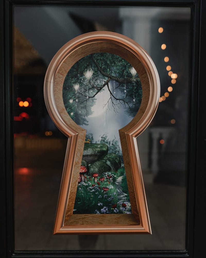 Gold keyhole-shaped frame around a painted forest scene with red mushrooms