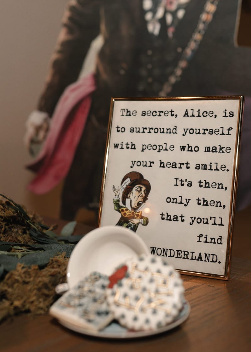 Framed Mad Hatter quote reading The secret, Alice, is to surround yourself with people who make your heart smile
