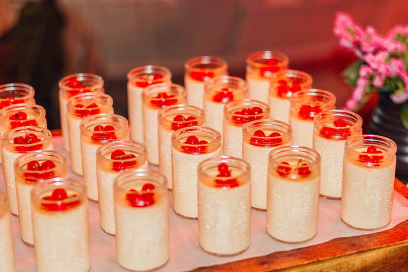 Rows of white dessert cups topped with red fruit