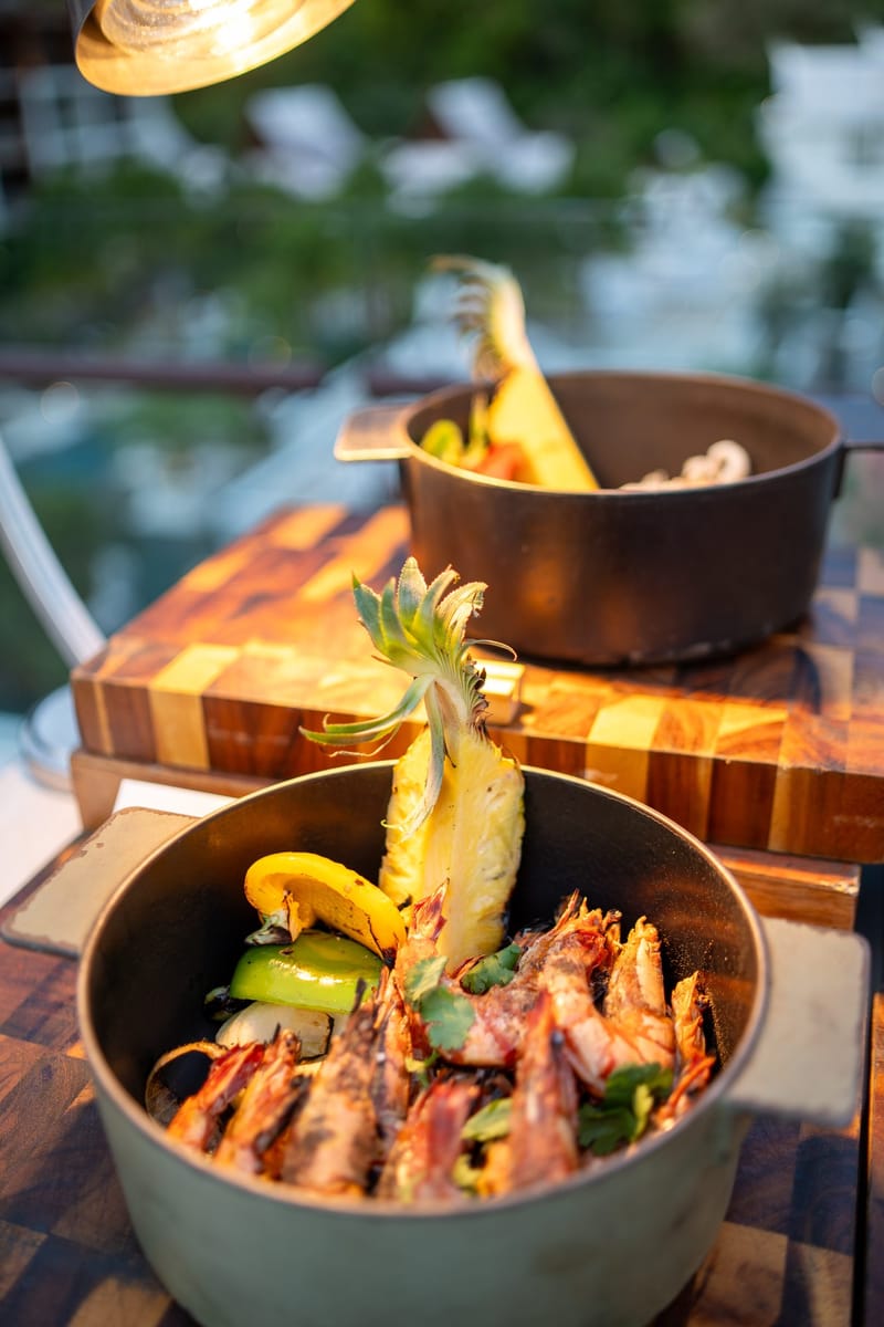 Grilled prawns with a pineapple garnish in a cast-iron pot