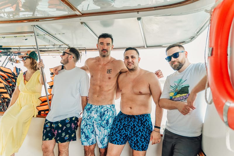 Five guests posing together on a yacht deck