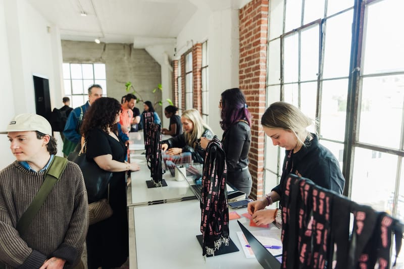 Check-in counter with rows of black and pink Connect lanyards