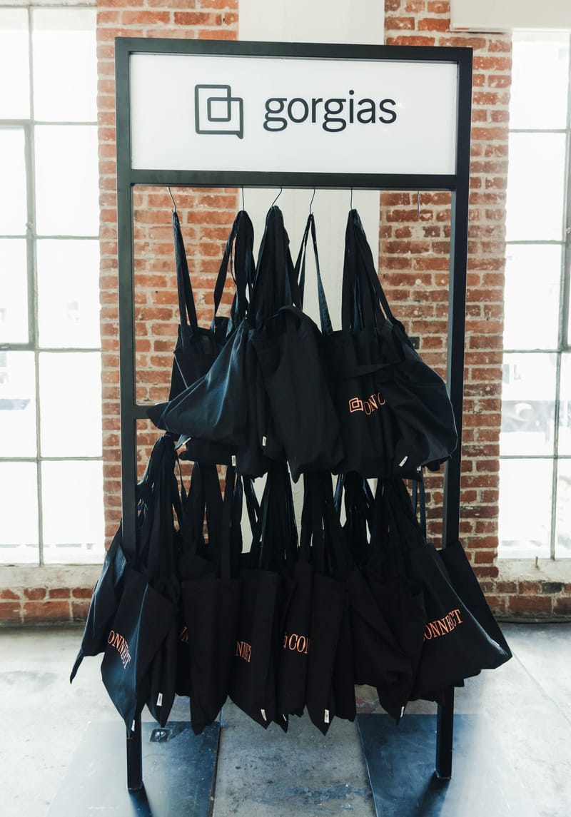 Black tote bags hanging on a rack with a Gorgias sign