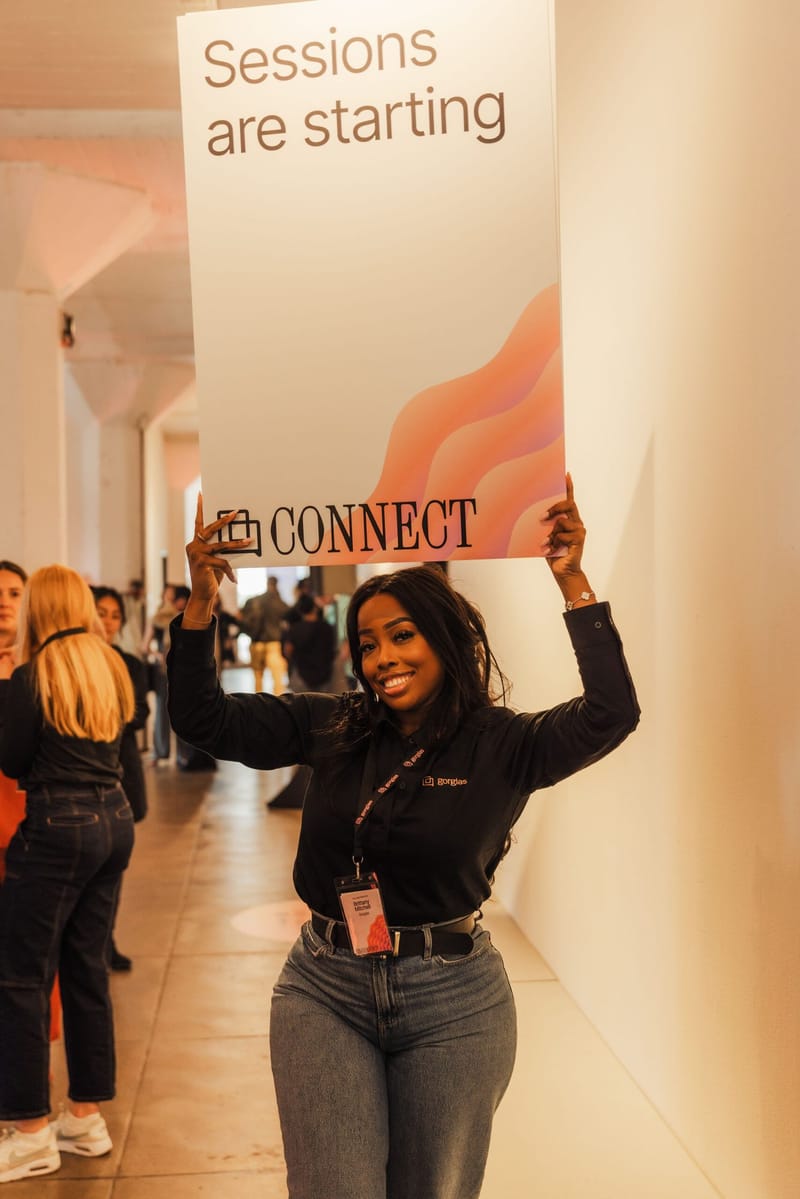 A staff member holding a Connect sign reading Sessions are starting