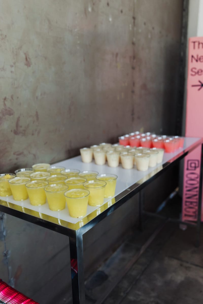 Table of yellow and pink juice cups beside a pink Connect banner