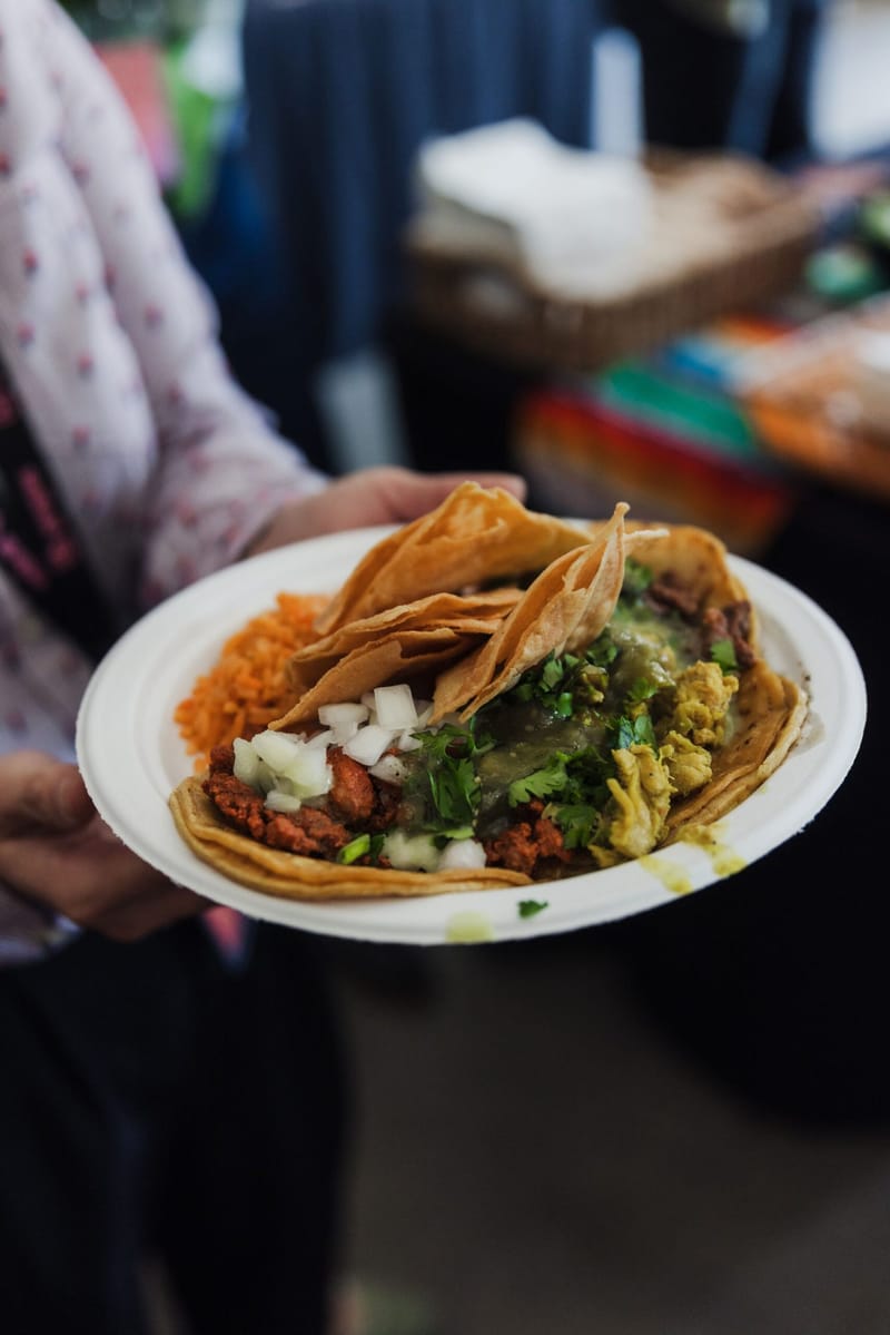 Plate of tacos topped with salsa and onions