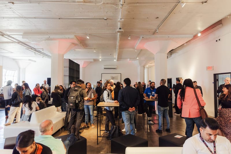 Crowded networking hall full of attendees standing and talking in small groups