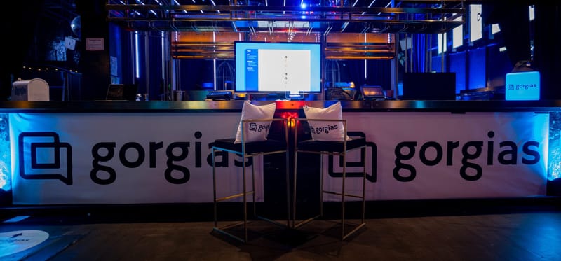 Bar front wrapped in Gorgias branding, with two stools holding Gorgias pillows