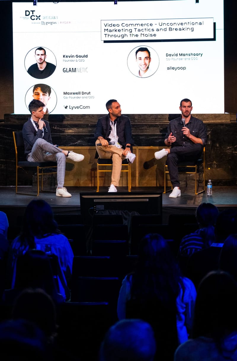 Three panelists on stage under a slide titled Video Commerce, facing a seated audience