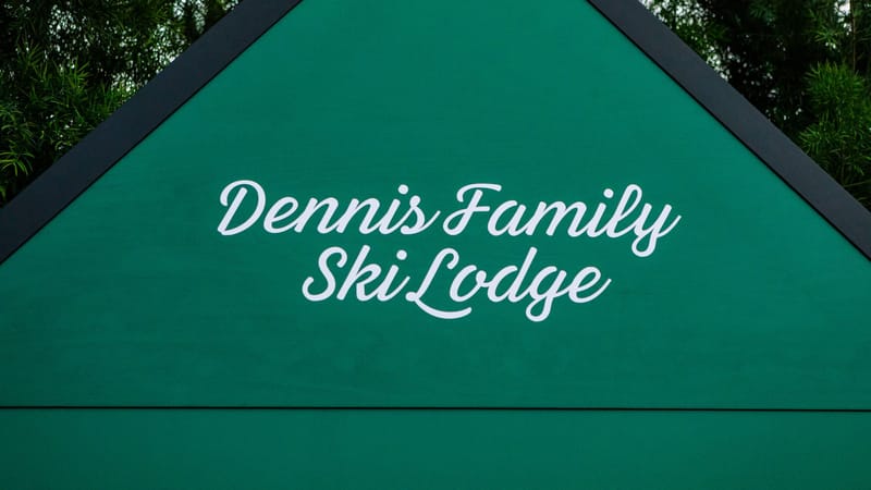 Green cabin gable painted with Dennis Family Ski Lodge in white script