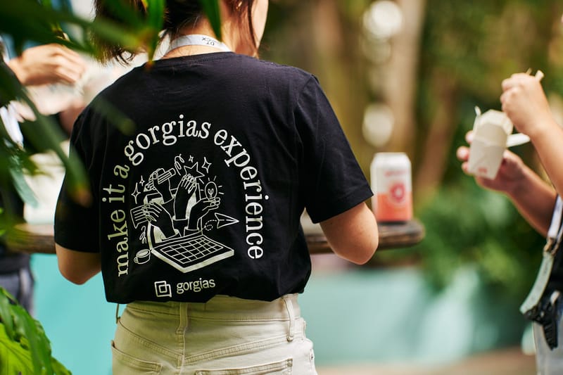 Person wearing a black T-shirt printed make it a gorgias experience