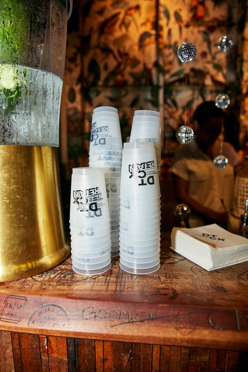 Stacks of clear DT CX Retain cups and napkins on a carved wooden bar