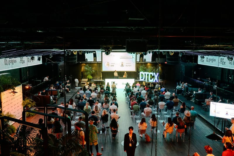 Overhead view of a full audience facing the DTCX stage in a large dark hall