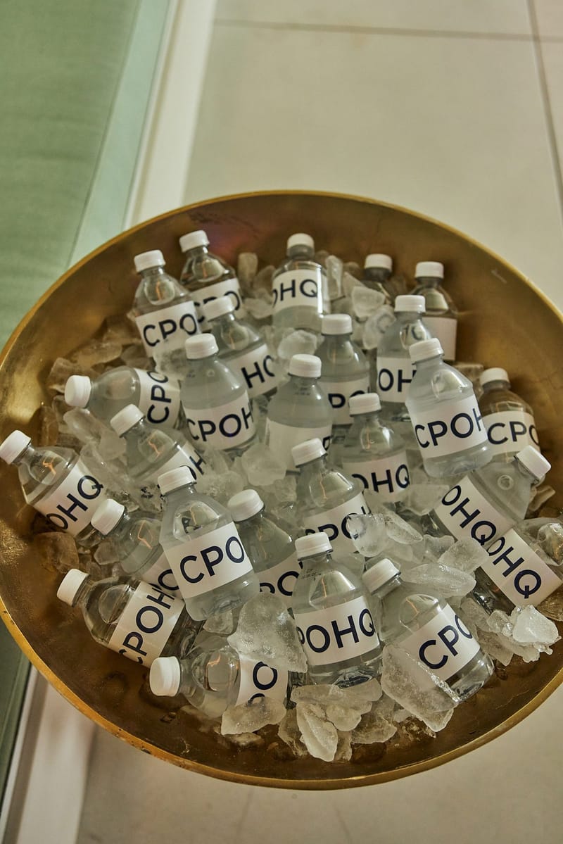 Gold bowl of ice filled with water bottles labeled CPOHQ