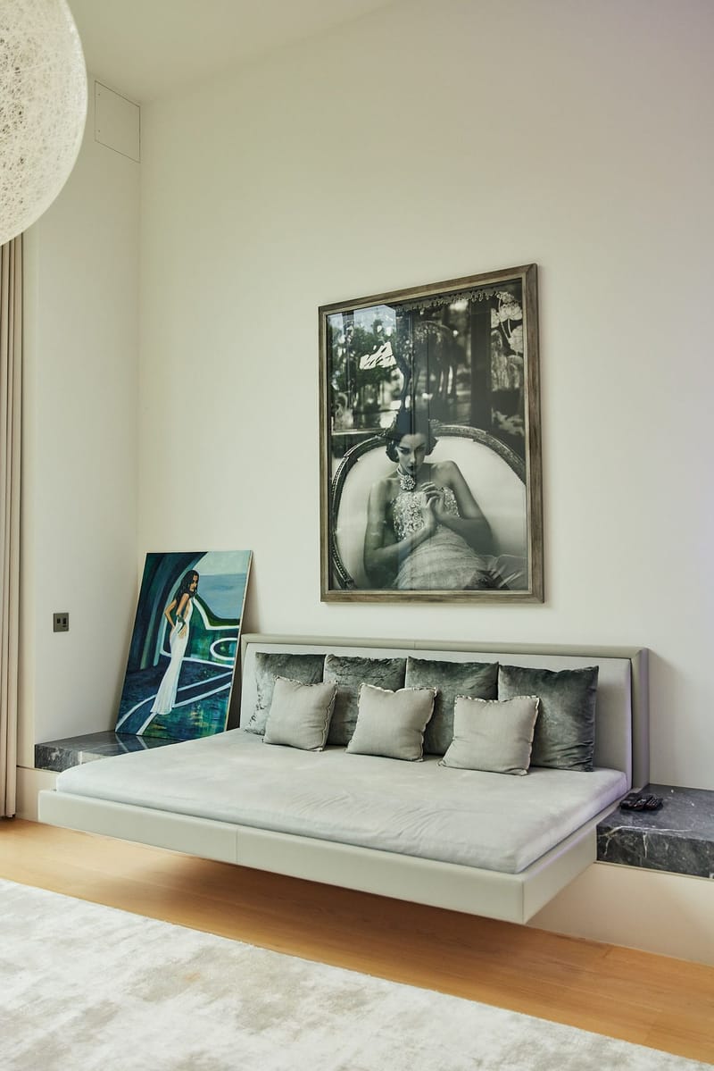 Floating daybed with gray cushions under a large black and white framed photograph