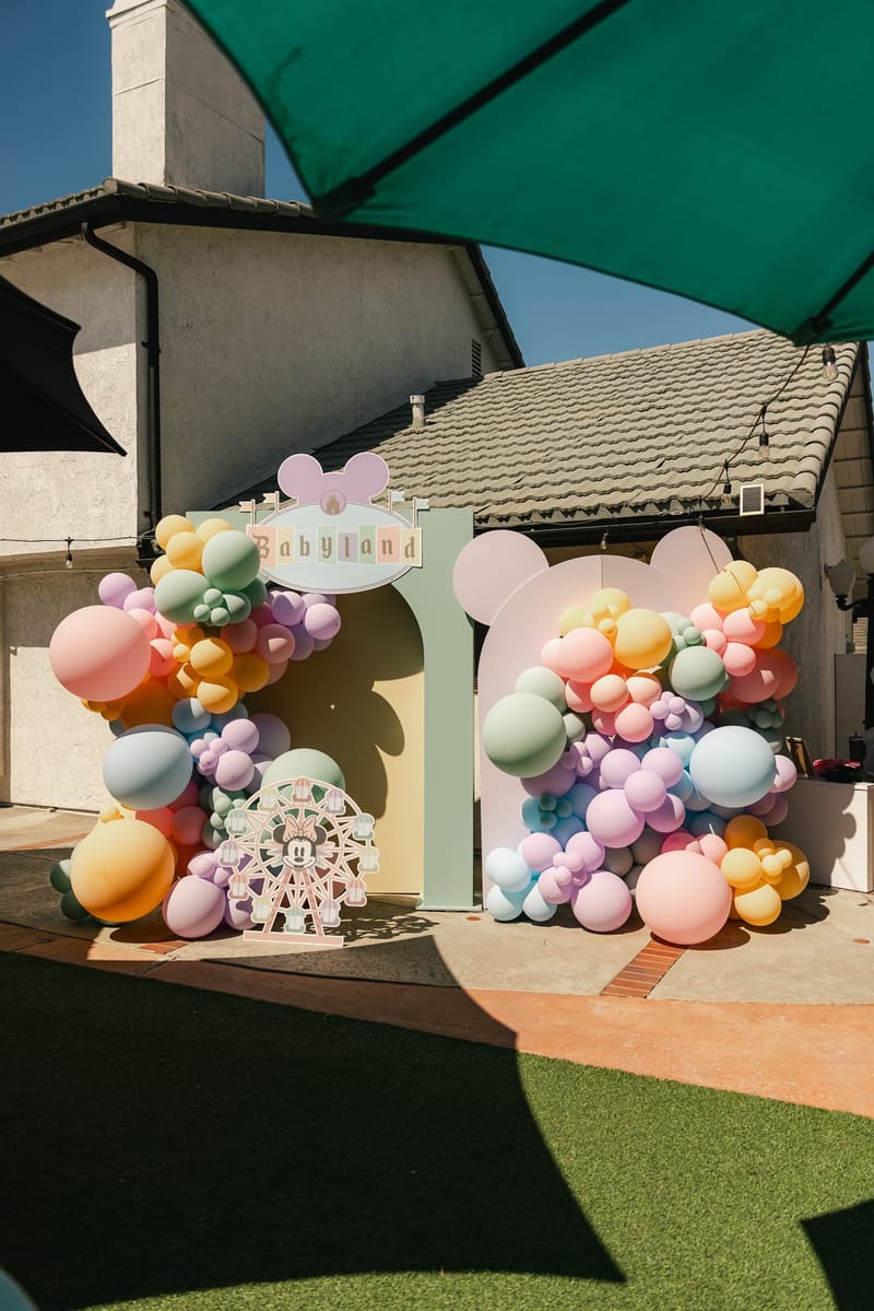 Babyland archway topped with Mickey ears and wrapped in pastel balloon garlands