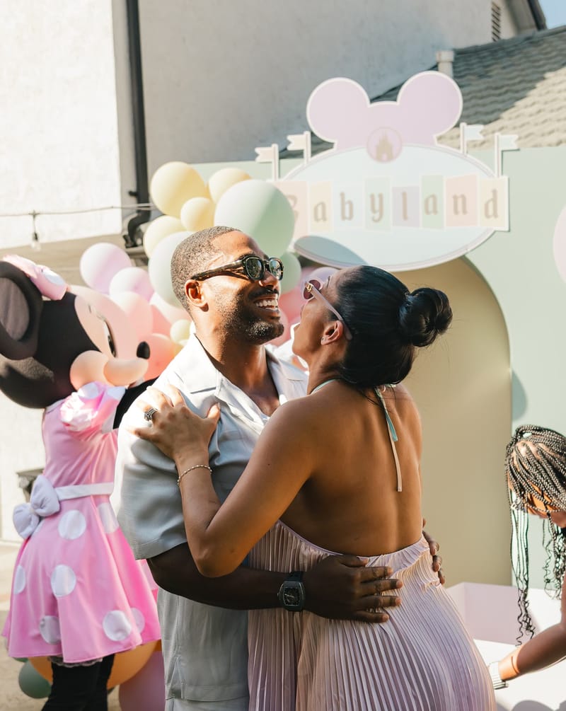 Jeaneth and Karlton embracing beside Minnie Mouse after the reveal