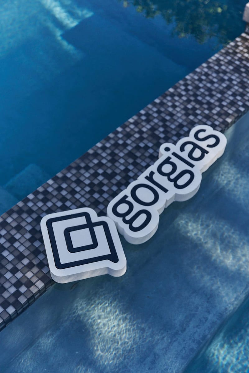 White Gorgias logo pool float resting against the mosaic tile edge of a pool