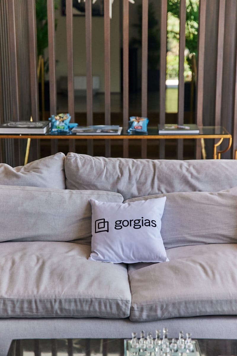 Gray sofa with a white Gorgias pillow among the cushions