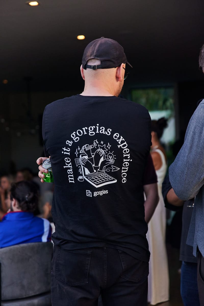 Back of a black T-shirt printed make it a gorgias experience with the Gorgias logo