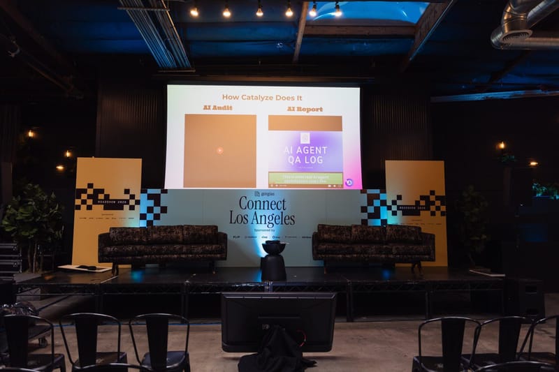 Stage with a large presentation screen, two sofas and checkerboard side panels