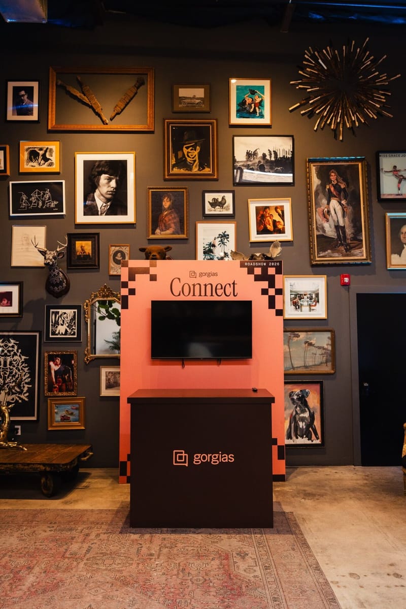 Coral Gorgias Connect kiosk with a screen in front of a wall of framed pictures