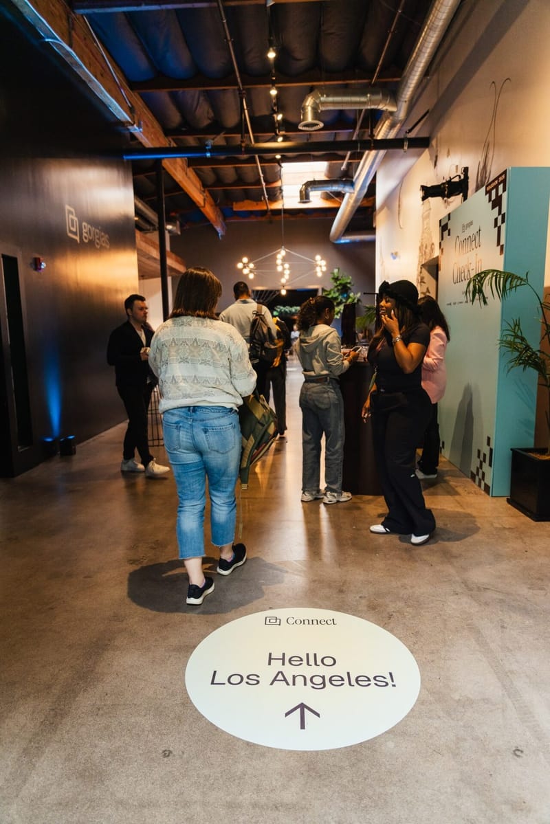 Floor decal reading Hello Los Angeles! with an arrow as guests walk into the venue