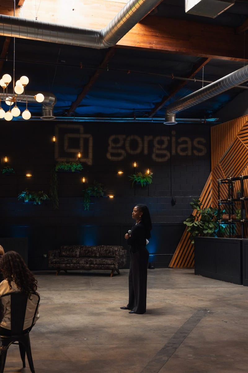 A guest standing in the main room in front of a large Gorgias wall sign